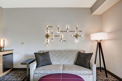 a living room with a couch and a tv at DoubleTree by Hilton Hotel Baton Rouge in Baton Rouge