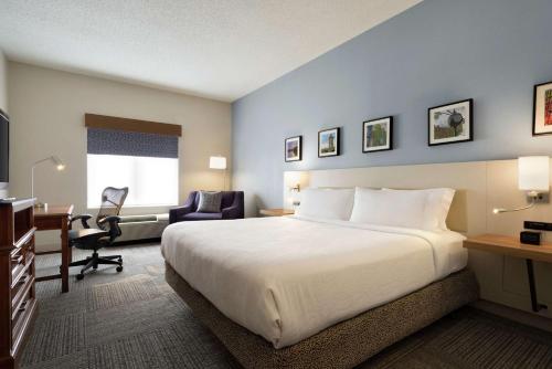 Habitación de hotel con cama grande y escritorio. en Hilton Garden Inn Wilkes-Barre en Wilkes-Barre