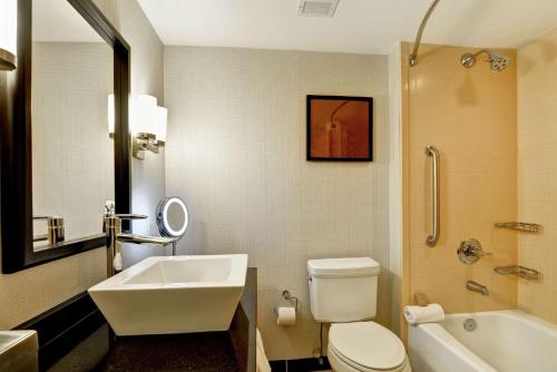 a bathroom with a sink and a toilet and a tub at DoubleTree by Hilton Baton Rouge in Baton Rouge