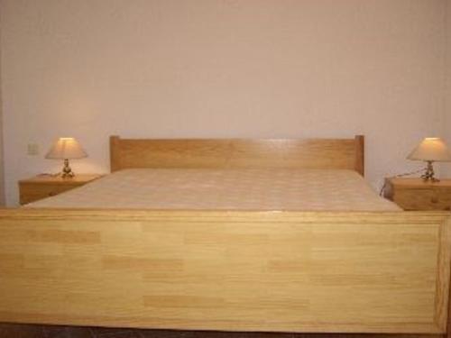 une chambre avec un lit en bois avec deux lampes dans l'établissement Palavas F2 cabine dernier étage, double terrasse, parking privé - FR-1-559-22, à Palavas-les-Flots