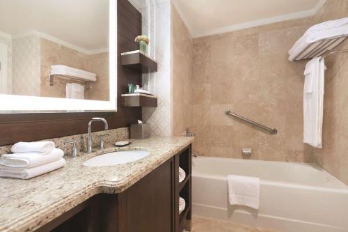 a bathroom with a sink and a bath tub at Hilton Los Angeles/San Gabriel in San Gabriel