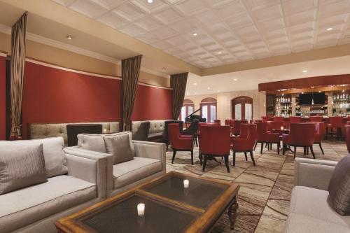 a bar with couches and chairs in a restaurant at Hilton Los Angeles/San Gabriel in San Gabriel