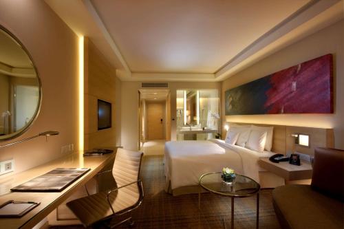 um quarto de hotel com uma cama grande e uma secretária em DoubleTree By Hilton Kuala Lumpur em Kuala Lumpur