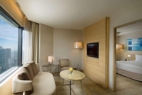 a hotel room with a bed and a couch and a table at DoubleTree By Hilton Kuala Lumpur in Kuala Lumpur