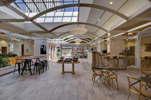 um saguão com mesas e cadeiras em um prédio em Hilton New Orleans Riverside em Nova Orleães