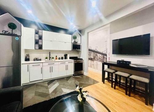 a kitchen with white cabinets and a black counter top at 2 Bedroom Apartment, Close to NYC & Downtown JC! in Jersey City