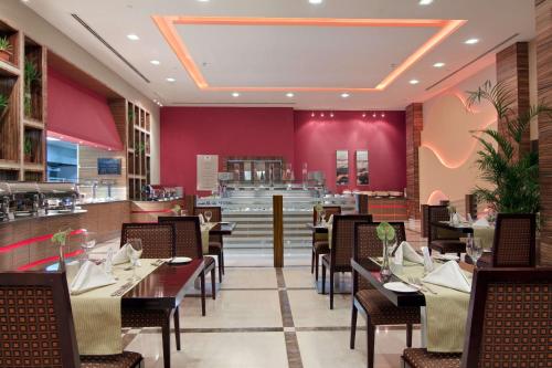 a dining room with tables and chairs in a restaurant at Hilton Garden Inn Riyadh Olaya in Riyadh