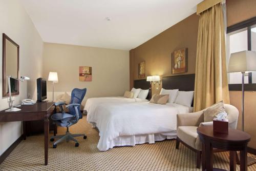 a hotel room with a bed and a desk and chair at Hilton Garden Inn Riyadh Olaya in Riyadh