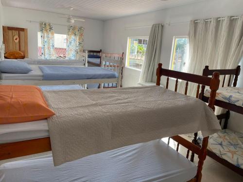 a bedroom with four beds and a window at Casa Amarela Hostel in Guarapari
