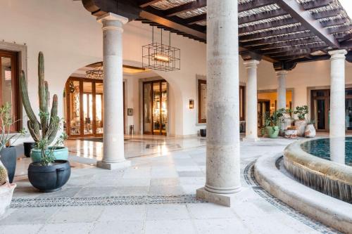 an indoor lobby with columns and a pool at Hilton Los Cabos in San José del Cabo