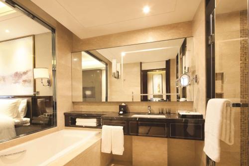 a bathroom with a sink and a large mirror at DoubleTree By Hilton Anhui in Suzhou