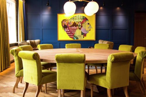 a dining room with a wooden table and green chairs at Canopy by Hilton Reykjavik City Centre in Reykjavík
