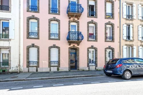 un'auto parcheggiata di fronte a un edificio rosa di L'industriel Brestois a Brest