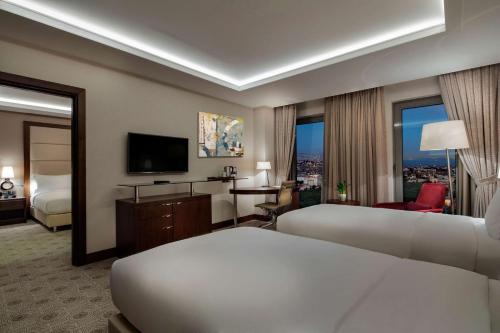 a hotel room with two beds and a television at Doubletree By Hilton Istanbul Topkapi in Istanbul