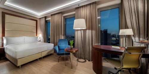 イスタンブールにあるDoubletree By Hilton Istanbul Topkapiのベッド、デスク、デスクが備わる客室です。