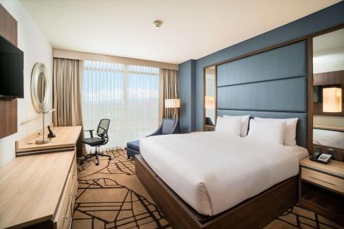 a hotel room with a bed and a desk at Hilton Garden Inn Bogota Airport in Bogotá