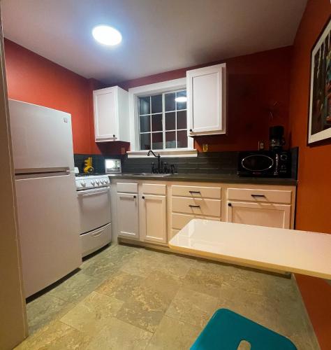 a kitchen with white appliances and red walls at Sessions Retreat & Hotel in Big Bear Lake