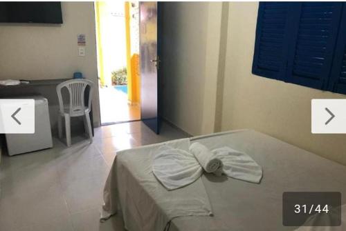 a bedroom with a bed and a table and a chair at POUSADA CÉU AZUL in Porto De Galinhas