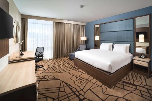 a hotel room with a bed and a desk at Hilton Garden Inn Bogota Airport in Bogotá