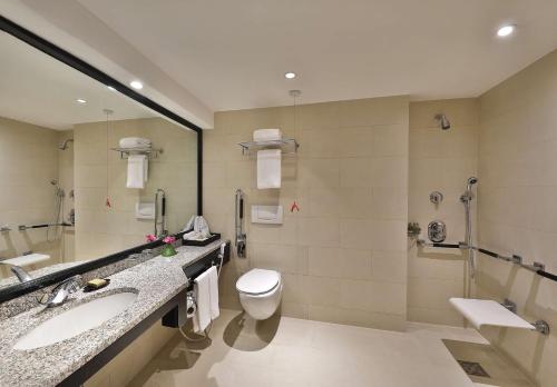 a bathroom with two sinks and a toilet and a shower at Hilton Cairo Heliopolis Hotel in Cairo