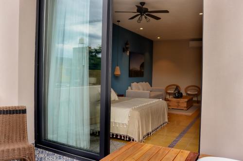 Hotel Boutique Gloriagave في تيكيلا: غرفة نوم مع سرير وغرفة معيشة