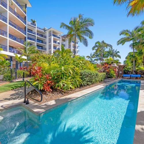 a swimming pool in front of a apartment building at The Mirage Resort Alexandra Headland in Alexandra Headland
