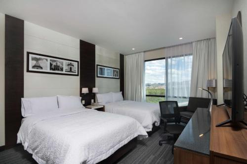 聖路易斯波托西的住宿－Hampton Inn By Hilton San Luis Potosi，酒店客房设有两张床和一台平面电视。