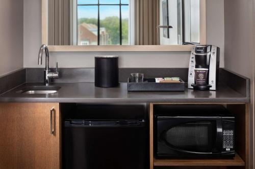 a kitchen with a sink and a microwave at Embassy Suites by Hilton South Bend in South Bend