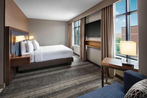 a hotel room with a bed and a large window at Embassy Suites by Hilton South Bend in South Bend