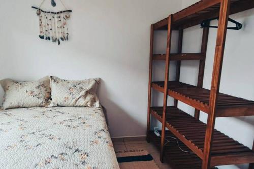 a bedroom with a bed and a wooden book shelf at Casa a poucos metros da praia! in Guaratuba