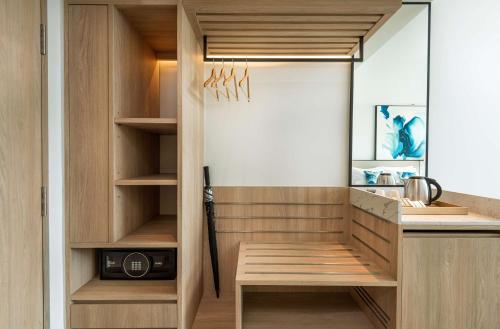 a kitchen with a walk in closet with wooden cabinets at Hilton Garden Inn Phuket Bang Tao in Bang Tao Beach