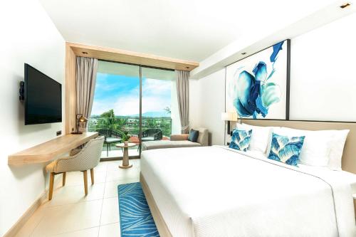 a hotel room with a bed and a large window at Hilton Garden Inn Phuket Bang Tao in Bang Tao Beach