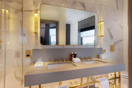 a bathroom with two sinks and a mirror at Hart Shoreditch Hotel London, Curio Collection by Hilton in London