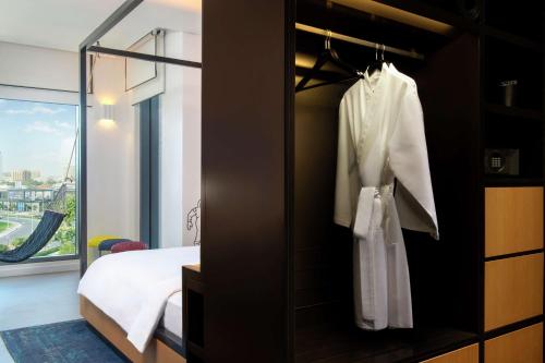 - une chambre avec un lit et un miroir dans l'établissement Canopy by Hilton Dubai Al Seef, à Dubaï