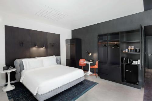a bedroom with a white bed and a black wall at Canopy by Hilton Dubai Al Seef in Dubai