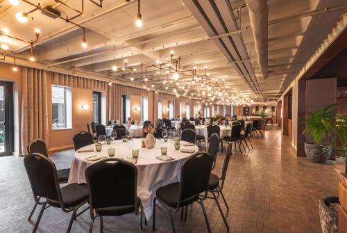 a large room with tables and chairs in a room at Canopy by Hilton London City in London