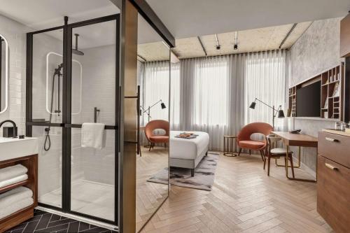a bathroom with a shower and a table and chairs at Canopy by Hilton London City in London