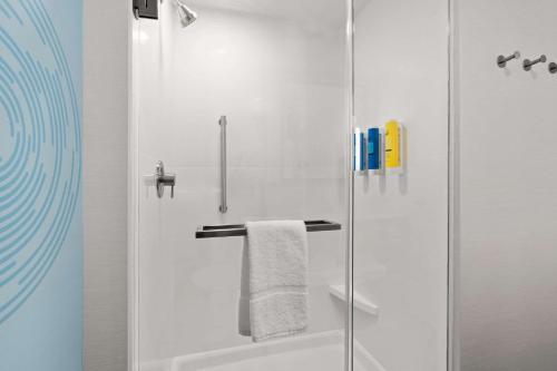 uma casa de banho com um chuveiro e uma toalha branca em Tru By Hilton Portland Airport, Or em Portland