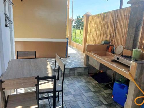 een patio met een tafel en stoelen en een wastafel bij Budget room with split type air-condition in San Fernando