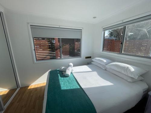 - une chambre avec un grand lit et 2 fenêtres dans l'établissement NRMA Shellharbour Beachside Holiday Park, à Shellharbour