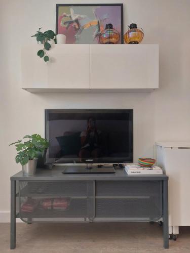 a flat screen tv sitting on top of a entertainment center at Cosy, Stylish, Central in Lisbon