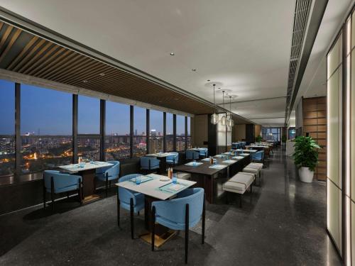 a restaurant with tables and chairs and windows at DoubleTree by Hilton Chengdu Riverside - Close to Panda Base and Chengdu East Railway in Chengdu