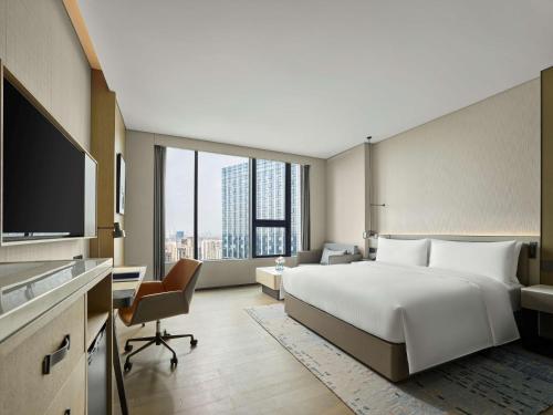 成都的住宿－成都滨江希尔顿逸林酒店，酒店客房设有一张大床和一张书桌。