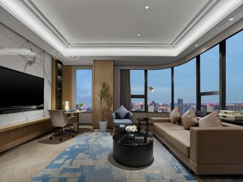 a living room with a couch and a flat screen tv at DoubleTree by Hilton Chengdu Riverside - Close to Panda Base and Chengdu East Railway in Chengdu