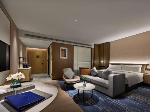 a hotel room with a bed and a couch at DoubleTree by Hilton Chengdu Riverside - Close to Panda Base and Chengdu East Railway in Chengdu