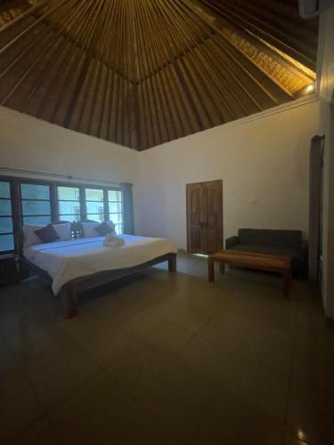 sypialnia z łóżkiem i ławką w pokoju w obiekcie El Homestay Bali w mieście Nusa Dua