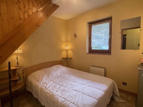 une chambre avec un lit blanc et une fenêtre dans l'établissement Appartement lumineux avec mezzanine à Praz-sur-Arly, parking, à 400m du lac - 4 pers. - FR-1-603-64, à Praz-sur-Arly