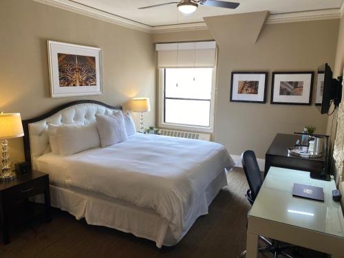 a bedroom with a large white bed and a desk at Kensington Park Hotel in San Francisco