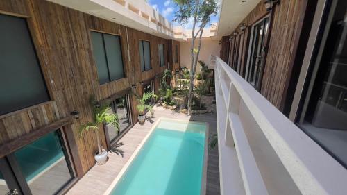 a balcony with a swimming pool next to a building at Harmonia Tulum in Tulum
