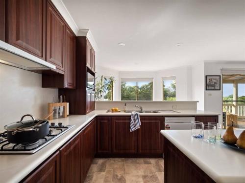 a kitchen with wooden cabinets and a stove top oven at Whale Watch Augusta Family Retreat in Augusta